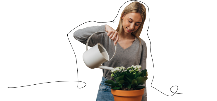 Woman smiling while watering a houseplant